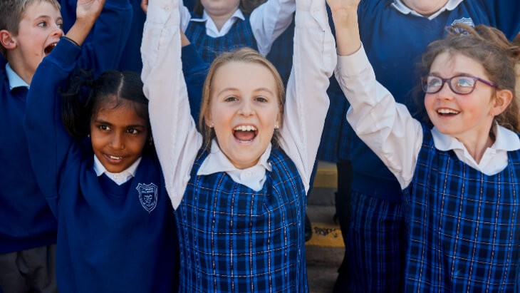 Draft_plan_for_NSW_public_education_SWS Happy primary school children smiling with their arms raised.